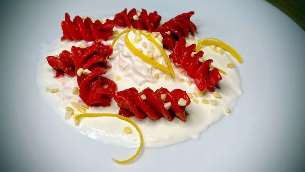 Red fusilloni with beetroot, almonds, and lemon on buffalo cream